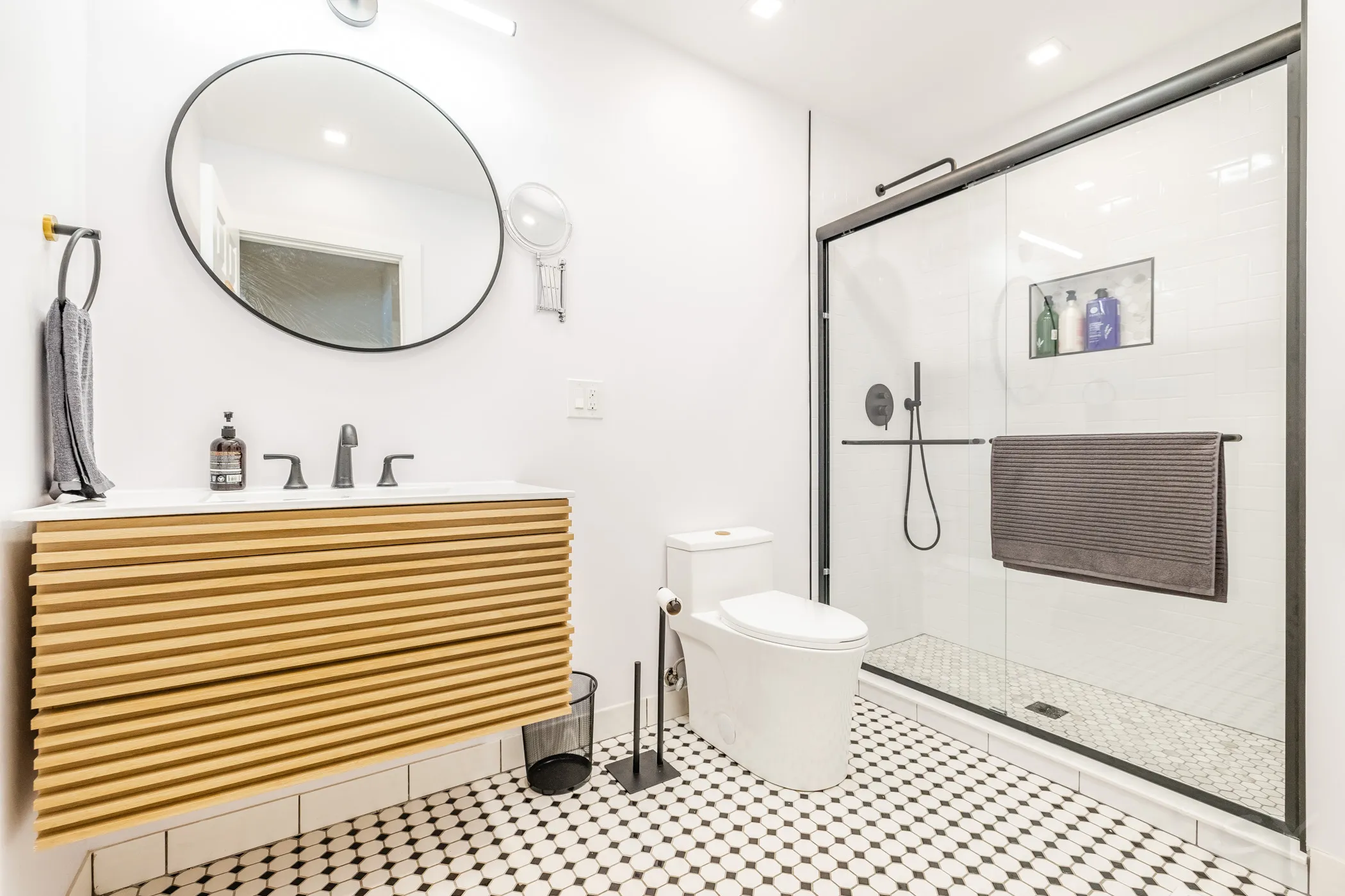 Wood-vanity bathroom with a subway-tile walk-in shower