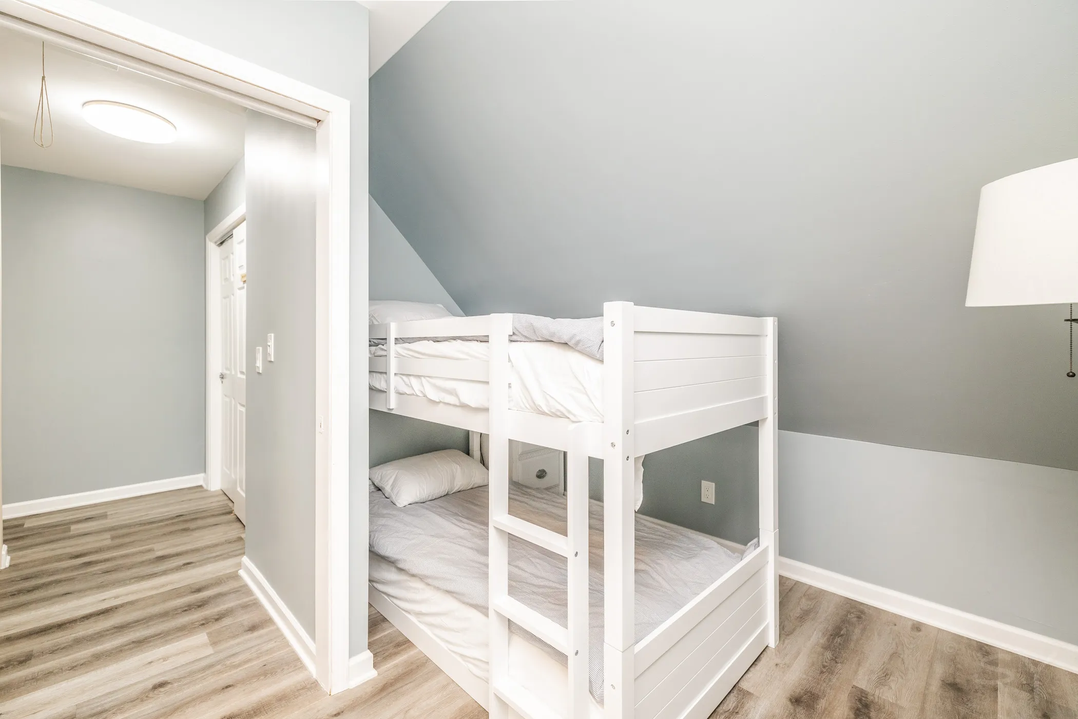 Bunk bed beside the doorway under a sloped ceiling