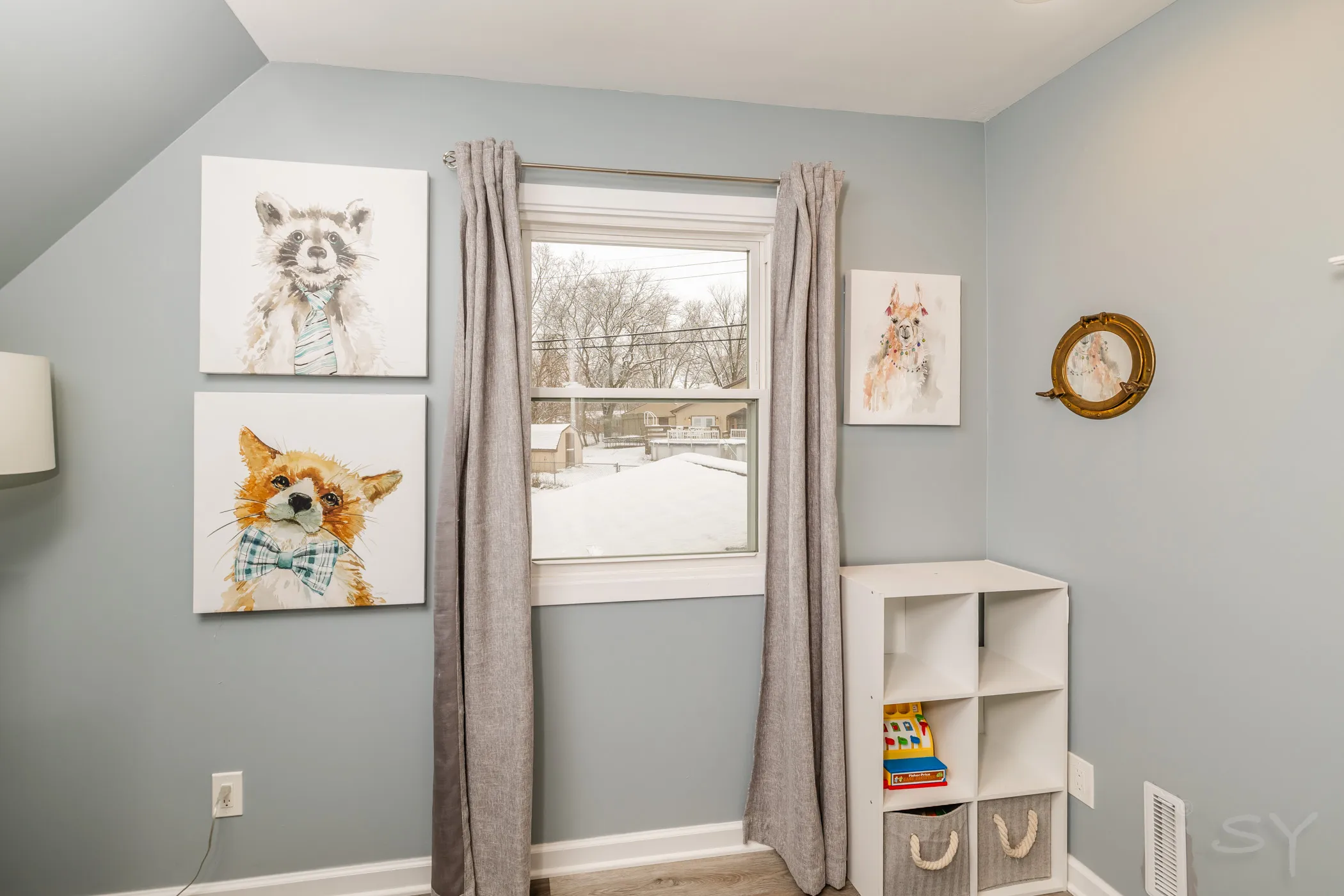 Kids' room corner with animal canvases and cube toy storage