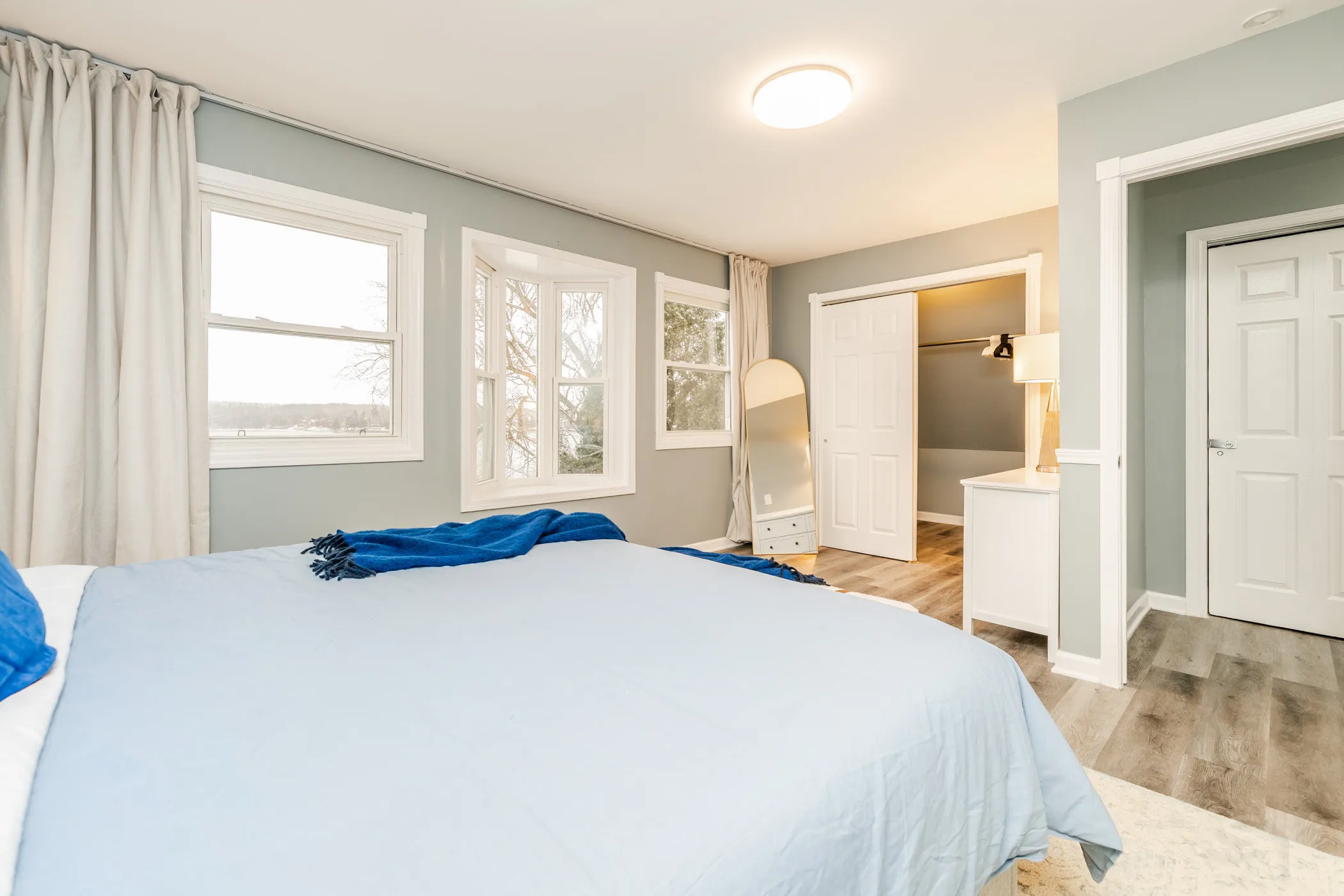 King bedroom with a bay window and walk-in closet