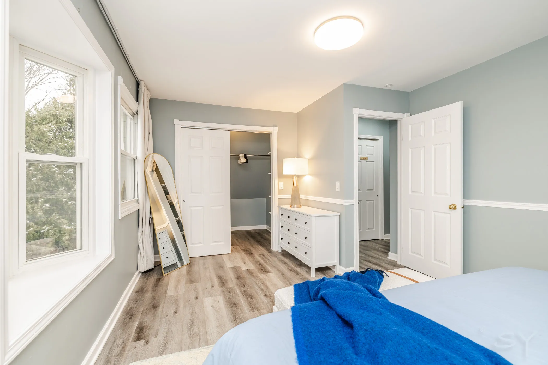 Upstairs master bedroom in soft grays with a blue throw