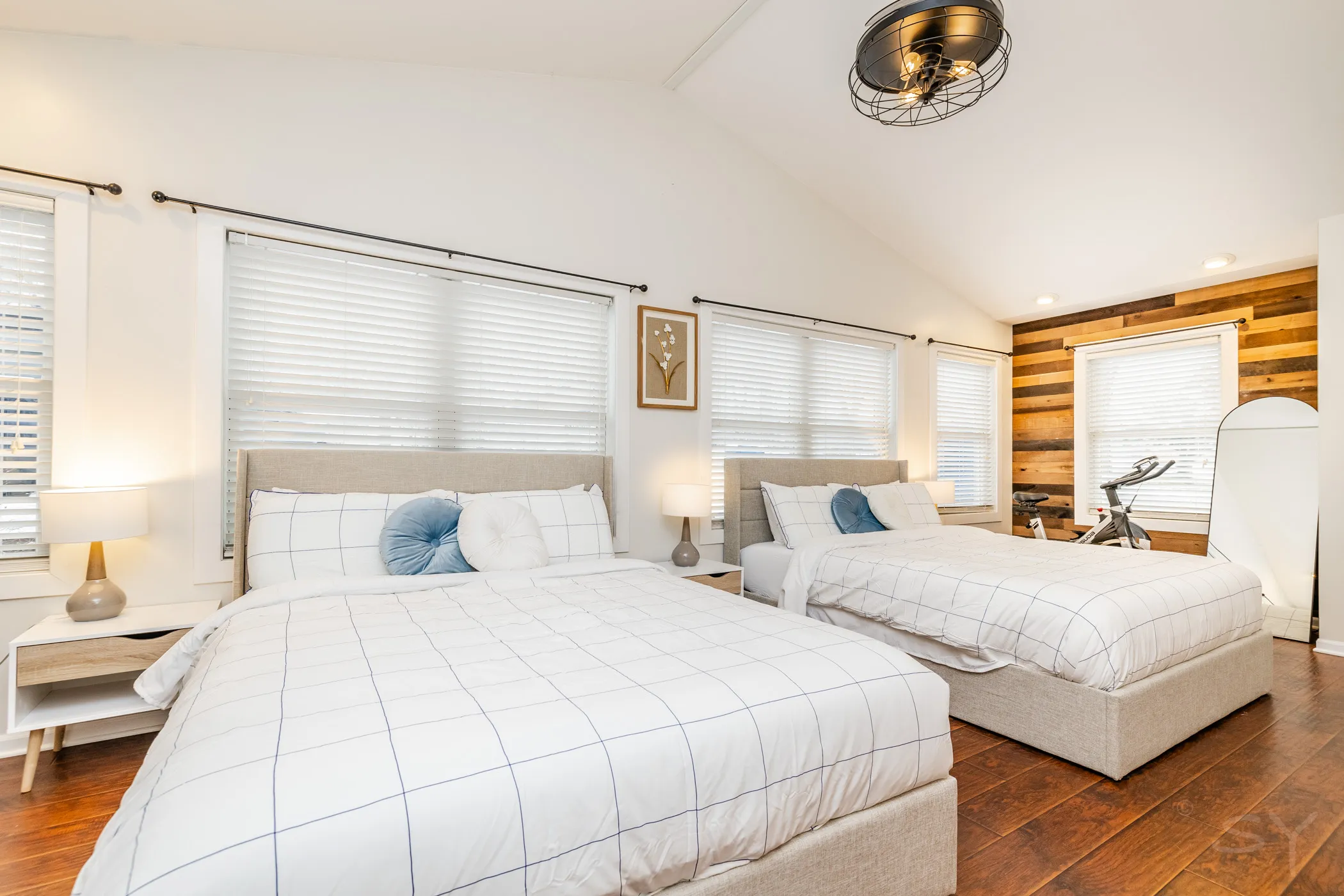 Bedroom with two queen beds and a reclaimed-wood accent wall