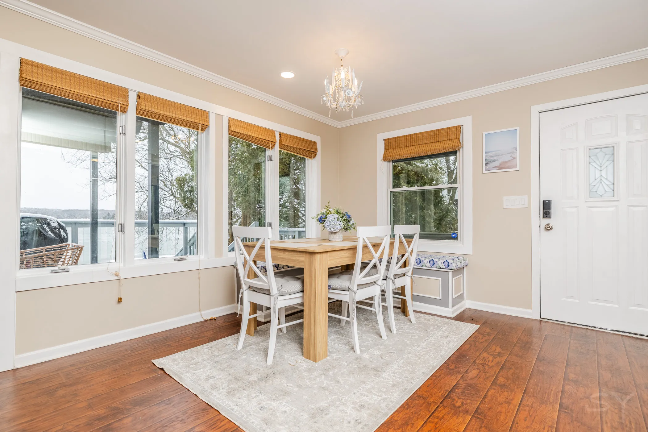 Dining table and chairs beside the lake-view windows