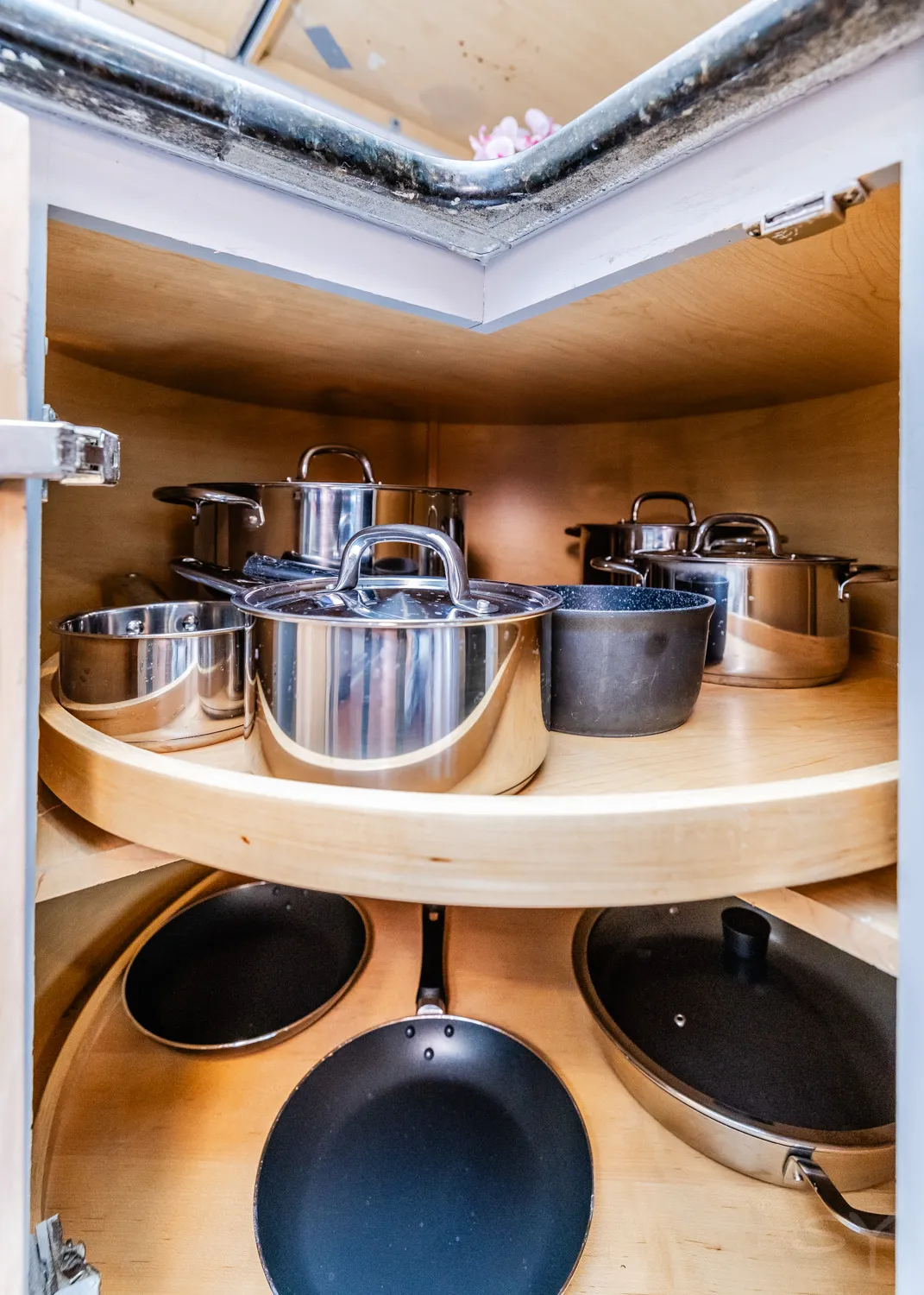 Corner lazy-Susan cabinet filled with pots and pans