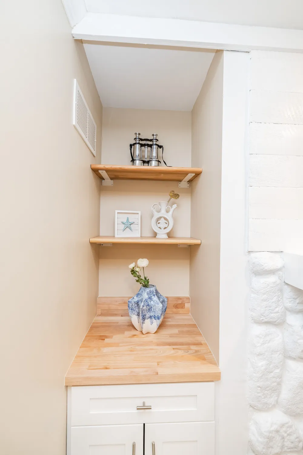 Built-in alcove shelving with decor beside the fireplace