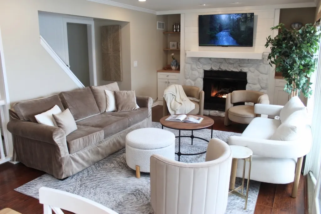 Cozy living room with a stone fireplace, sofa and accent chairs