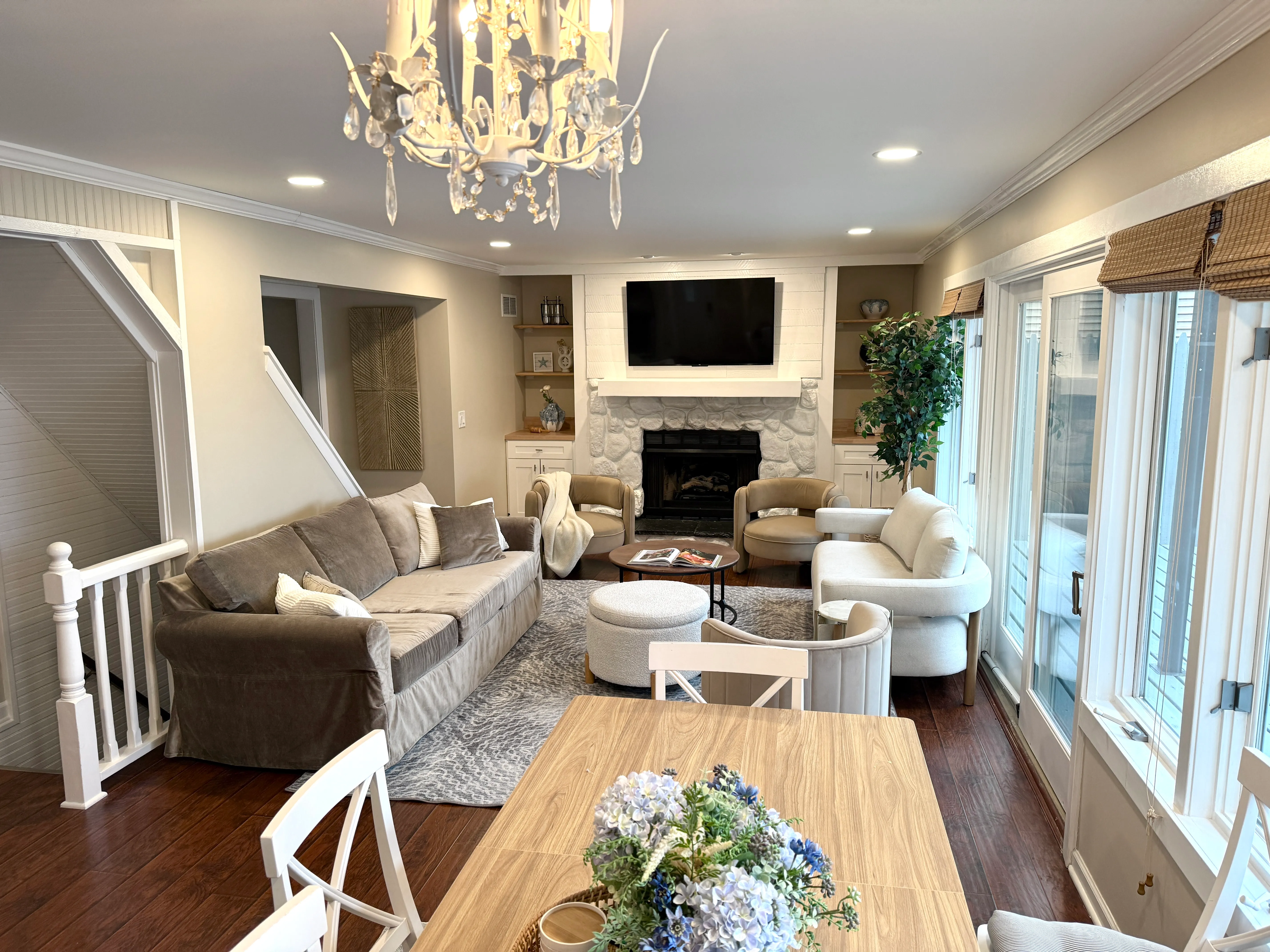 Great room with a chandelier, fireplace and wood dining table