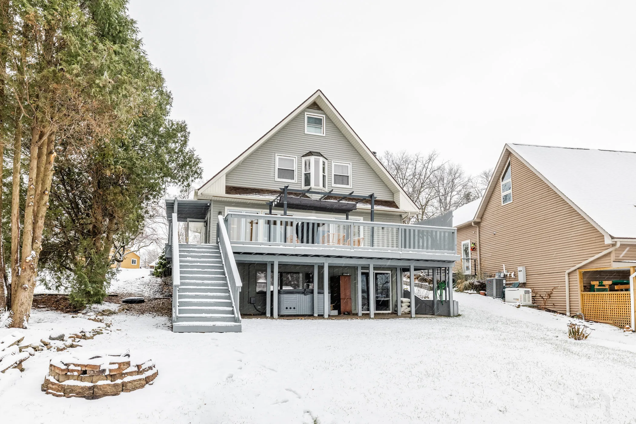 Rear exterior with the multi-level deck and pergola in winter
